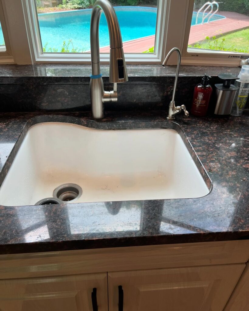 Plumber repairing leaking kitchen sink drain connectionc