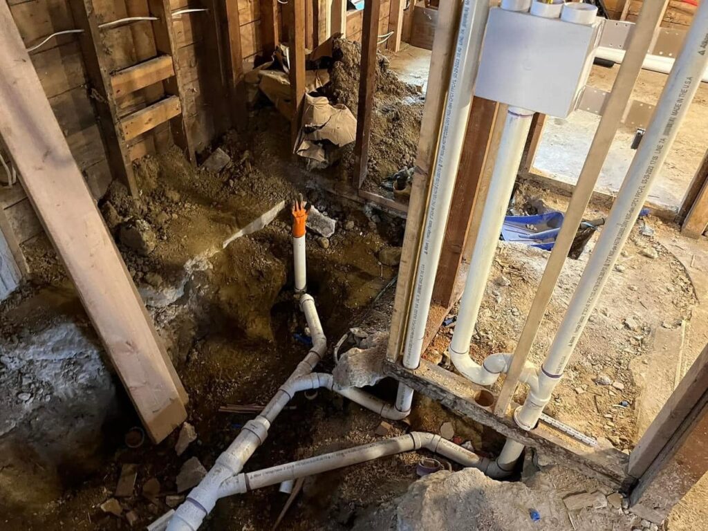 Plumber replacing damaged section of residential sewer pipe