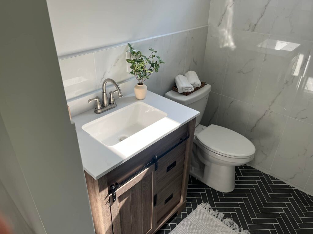 Plumber installing new bathroom sink shutoff valves during renovation