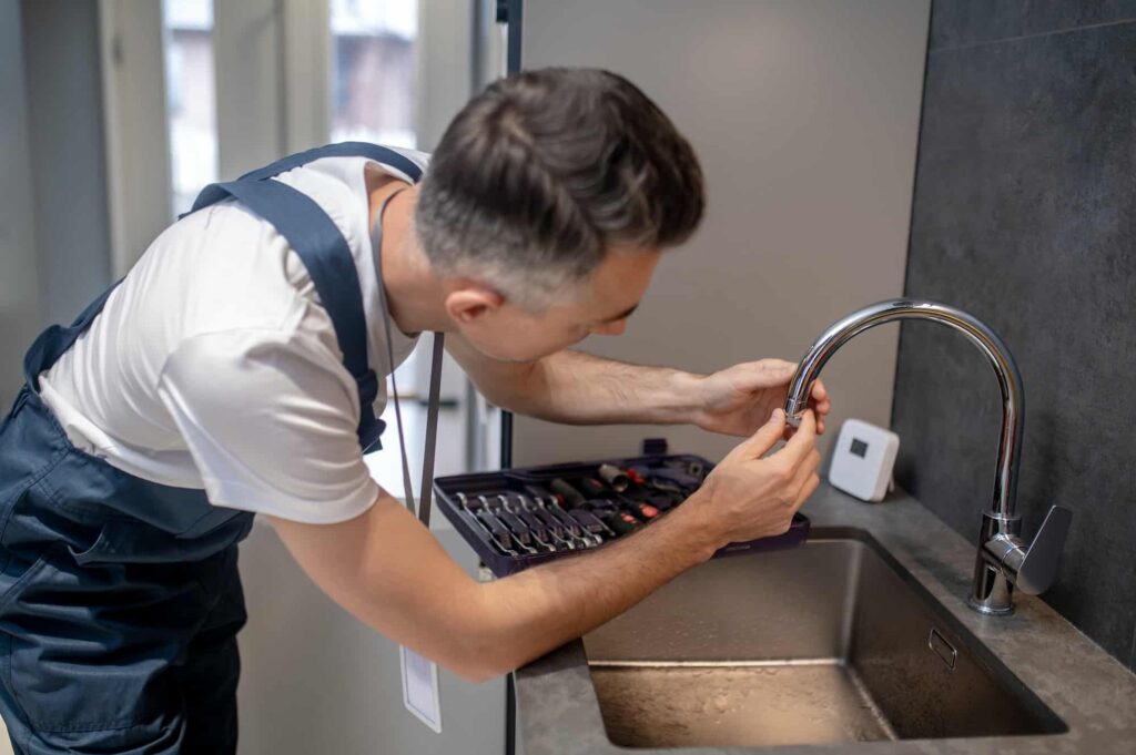 Plumber installing new kitchen sink disposal flange assembly