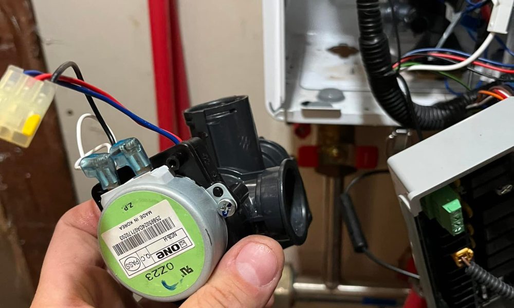 Heating technician inspecting boiler pressure gauge in basement