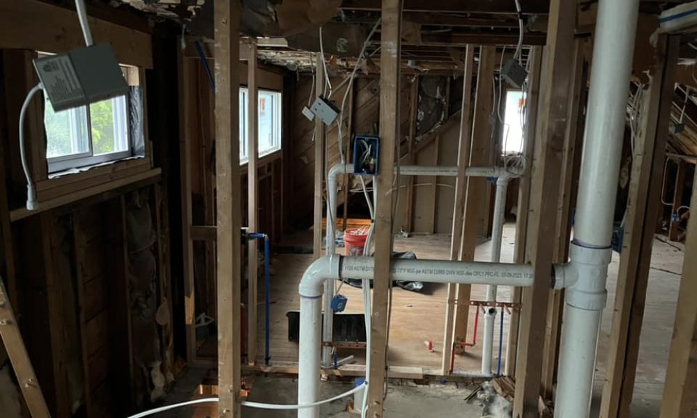 Plumber repairing cracked PVC pipe in basement