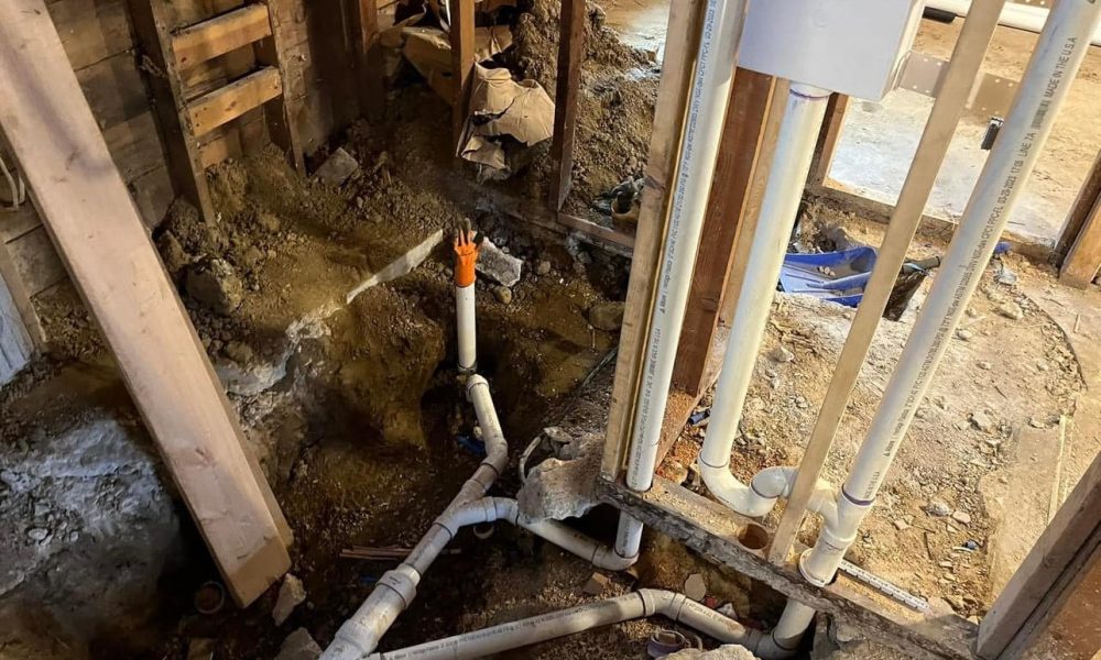 Plumber replacing damaged section of residential sewer pipe